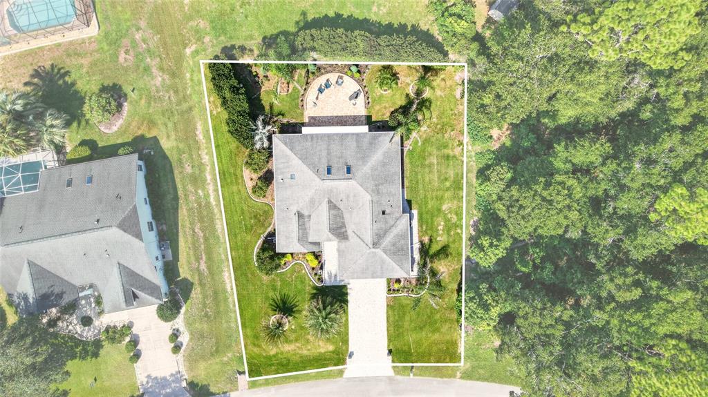An aerial view shows a house with a paved driveway and a backyard patio area — 9636 SW 190TH TERRACE ROAD, DUNNELLON, FL