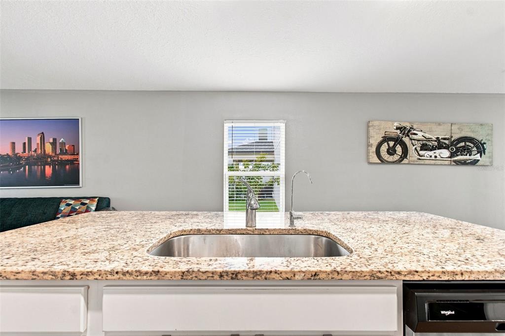 A view from an entryway looking down a hallway toward a living room with wood floors — 5271 CRICKET ROAD, BROOKSVILLE, FL
