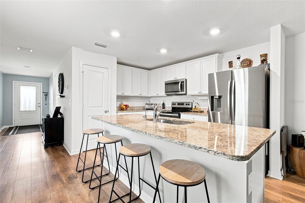 A kitchen island with a granite countertop and stainless steel sink sits before a window — 5271 CRICKET ROAD, BROOKSVILLE, FL