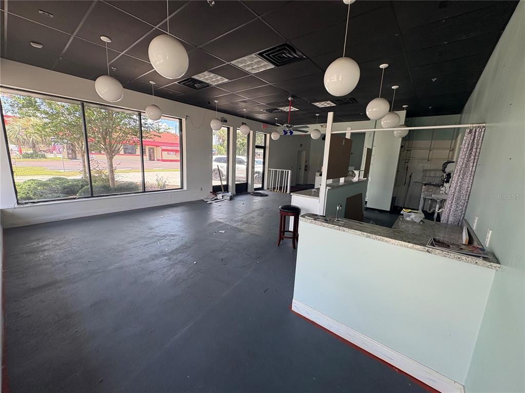 An empty commercial space features a black drop ceiling, pendant lights, and a service counter — 80 N CENTRAL AVENUE, UMATILLA, FL