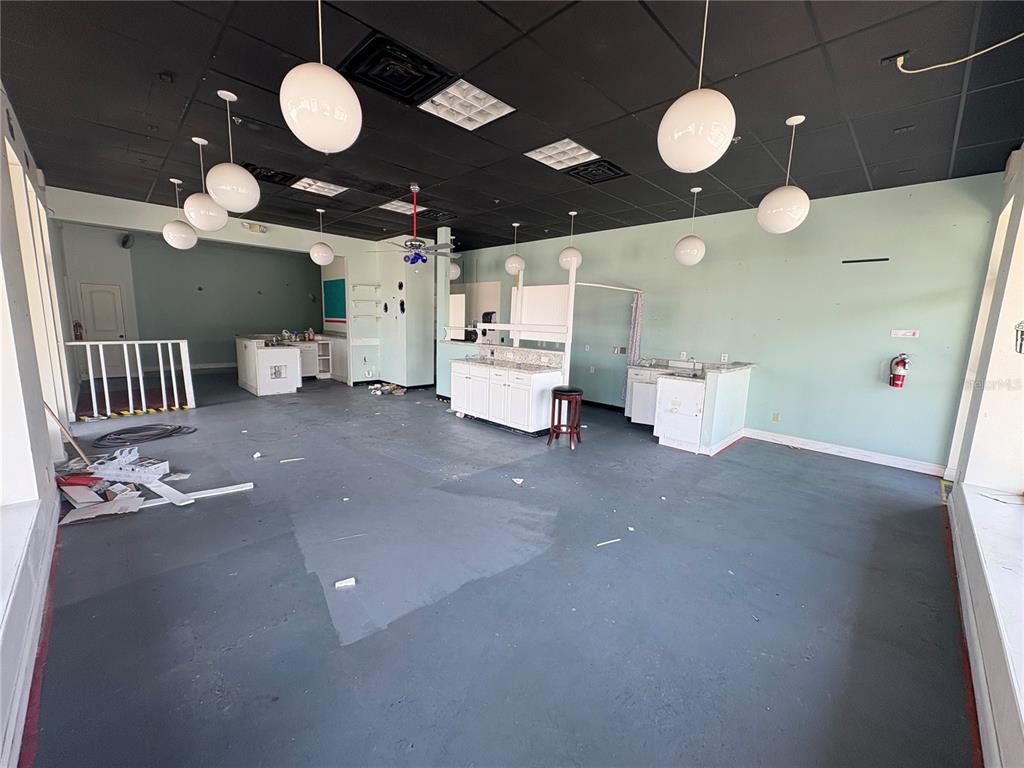 An empty commercial space features a black drop ceiling, pendant lights, and several white cabinets — 80 N CENTRAL AVENUE, UMATILLA, FL