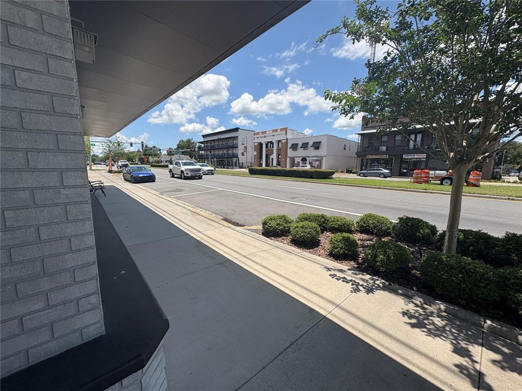 A sidewalk runs alongside a street with parked cars and buildings under a blue sky — 80 N CENTRAL AVENUE, UMATILLA, FL