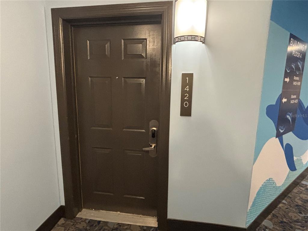 A brown door with a room number sign is located in a hallway with blue walls — 14501 GROVE RESORT AVENUE UNIT 1420, WINTER GARDEN, FL