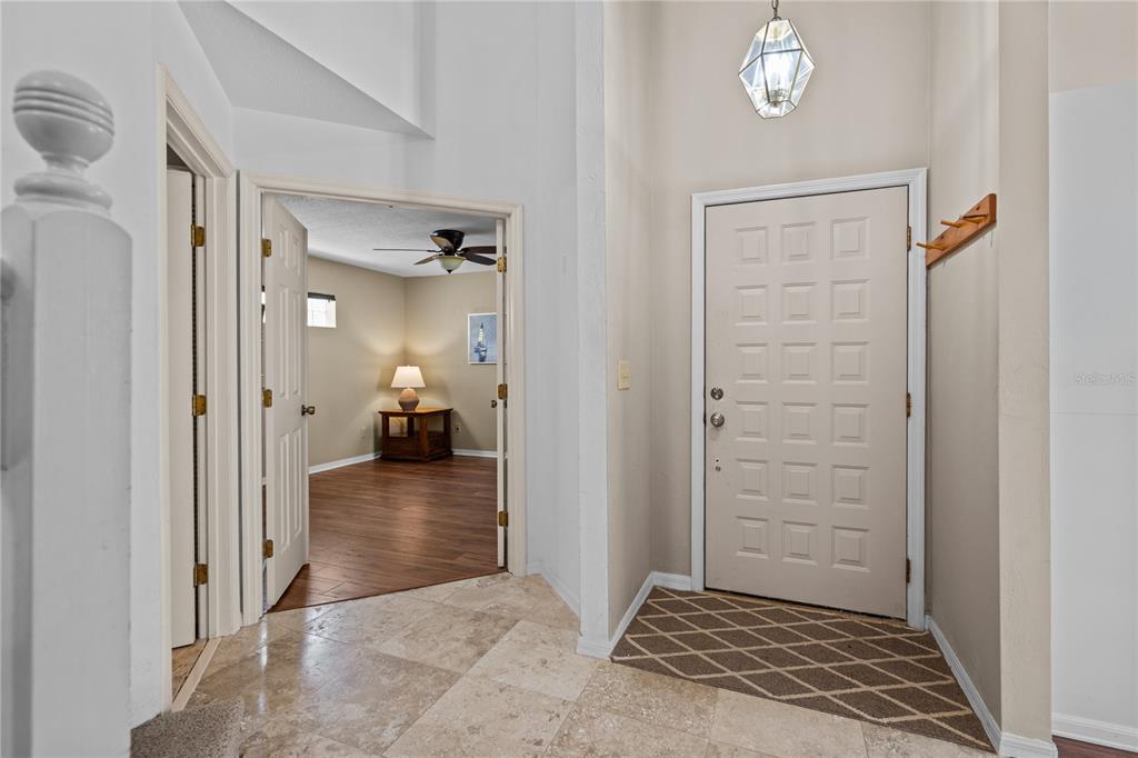 An entryway features a tiled floor, a white paneled door, and a view into a room — 254 GLENBRIAR CIRCLE, DAYTONA BEACH, FL