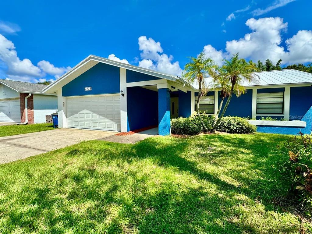 A blue single-story house with a white garage door and palm trees in the front yard — 2775 DIANE TERRACE, CLEARWATER, FL
