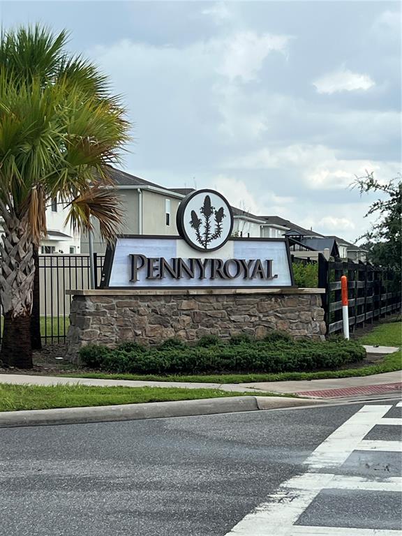 A stone monument sign for the Pennyroyal community stands near a palm tree and road — 1582 SEPAL STREET, KISSIMMEE, FL