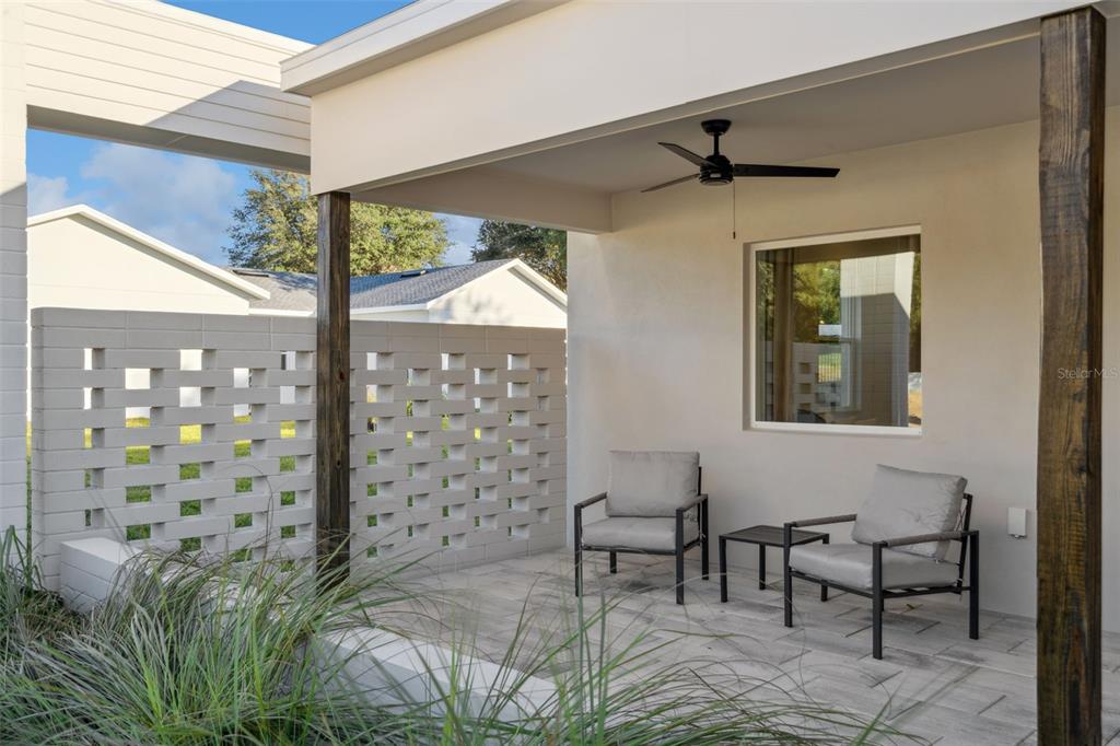 A living room features a white sectional sofa, a black coffee table, and beige curtains — 439 SKYFIELD COURT, LADY LAKE, FL