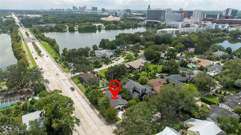 An aerial view shows a residential house marked with a red pin near a road — 1124 MUNSTER STREET, ORLANDO, FL