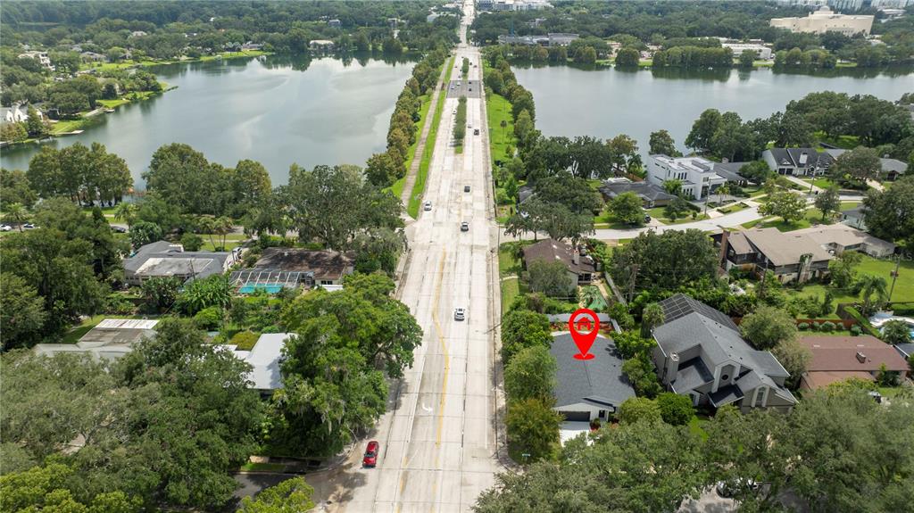 An aerial view shows a house with a red location pin near a divided road — 1124 MUNSTER STREET, ORLANDO, FL