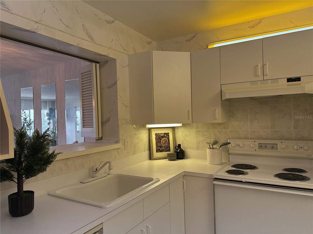 A dining area with a glass table and chairs sits in front of mirrored wall panels — 100 BLUFF VIEW DRIVE UNIT 609A, BELLEAIR BLUFFS, FL