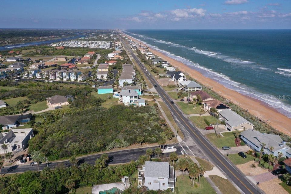 An aerial view shows a coastal road separating residential homes from the ocean beach — 2584 N OCEAN SHORE BOULEVARD, FLAGLER BEACH, FL