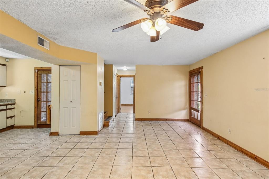 A tiled dining area features a ceiling fan, yellow walls, and a glass-paneled exterior door — 2702 49TH STREET S, GULFPORT, FL