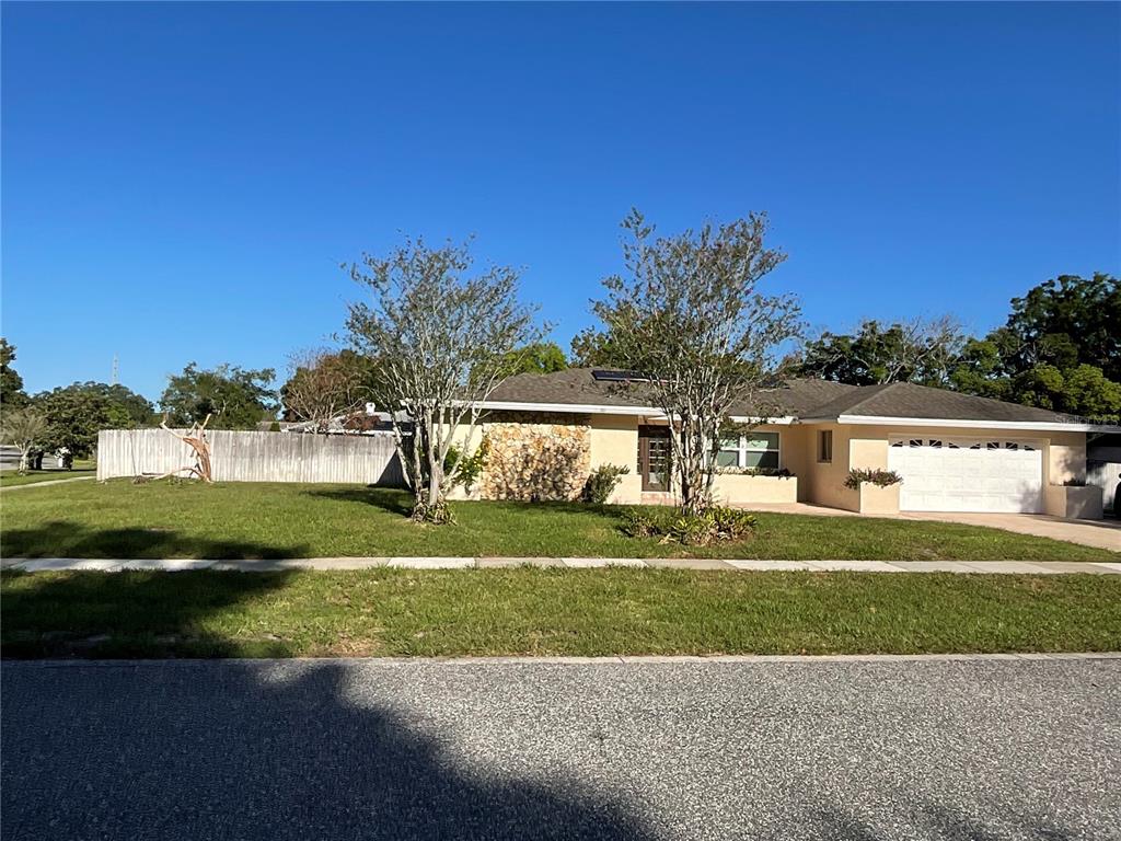 A single-story house with a stone facade, two trees in the front yard, and a garage — 6004 HARDROCK CIRCLE, ORLANDO, FL