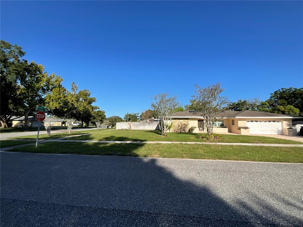 A single-story house with a white garage and a large front lawn under a clear sky — 6004 HARDROCK CIRCLE, ORLANDO, FL