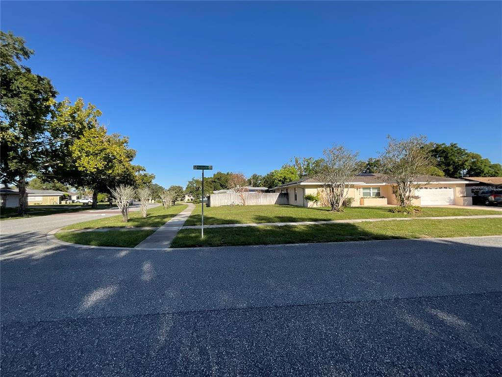 A single-story house with a lawn and sidewalk viewed from a street corner — 6004 HARDROCK CIRCLE, ORLANDO, FL