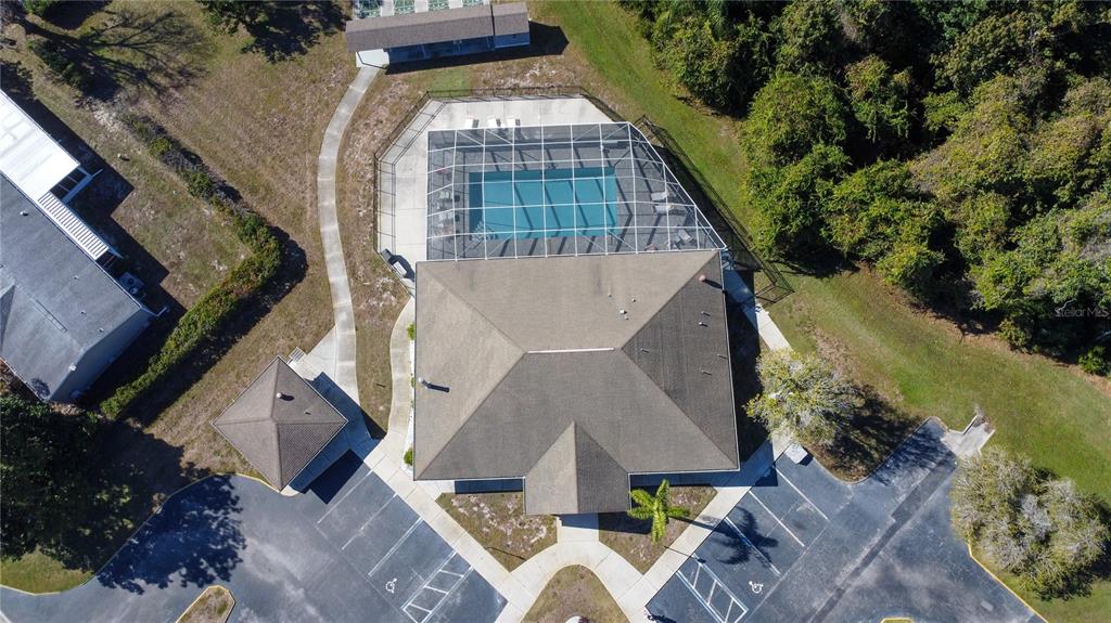 An aerial view shows a community building with a screened-in pool and parking lot — FOREST GLENN DRIVE, SPRING HILL, FL