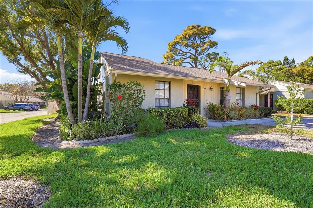 A single-story house with a tan exterior, palm trees, and a car parked in front — 36 WINDRUSH BAY DRIVE UNIT 36, TARPON SPRINGS, FL