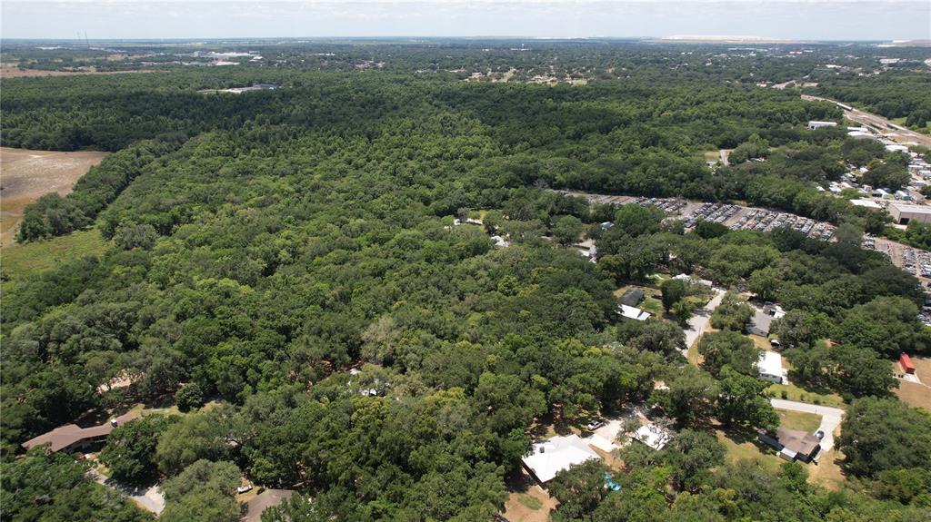An aerial view shows a wooded residential area with scattered houses and a large parking lot — MOOSE LODGE ROAD, BARTOW, FL