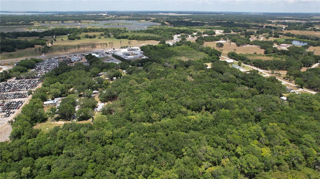 An aerial view shows a large, wooded lot adjacent to a commercial area and parking lot — MOOSE LODGE ROAD, BARTOW, FL