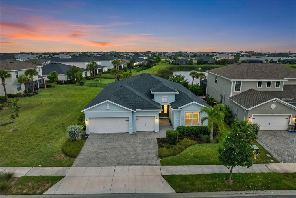 An aerial view of a light blue single-story house with a three-car garage — 17661 FALLEN BRANCH WAY, PUNTA GORDA, FL