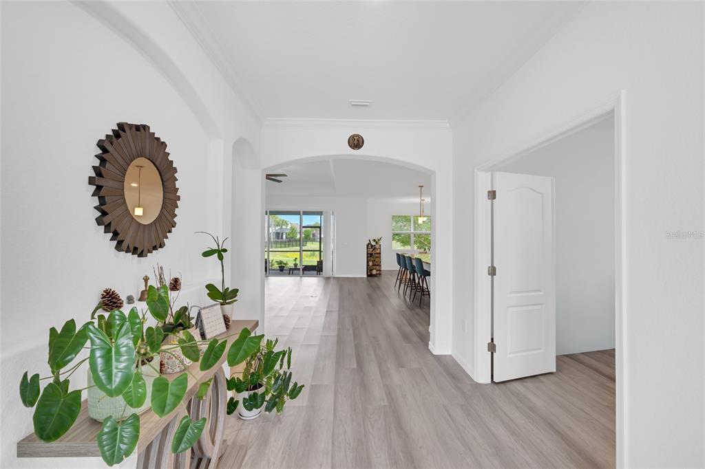A bright entryway leads into an open-concept living area with light wood-look flooring — 17661 FALLEN BRANCH WAY, PUNTA GORDA, FL