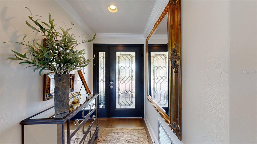 An entryway features a dark front door with glass panels, a mirrored console, and a mirror — 40 MAGNOLIA DRIVE S. UNIT 0, ORMOND BEACH, FL