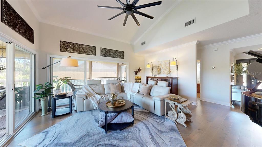 A living room features a white sectional sofa, a round coffee table, and vaulted ceilings — 40 MAGNOLIA DRIVE S. UNIT 0, ORMOND BEACH, FL