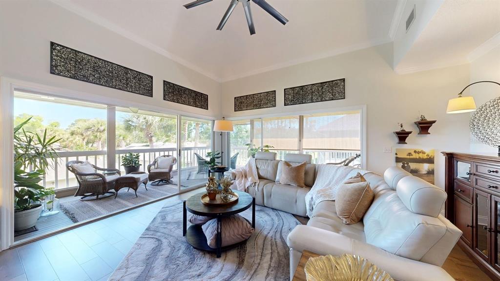 A living room features a sectional sofa, a round coffee table, and sliding glass doors — 40 MAGNOLIA DRIVE S. UNIT 0, ORMOND BEACH, FL