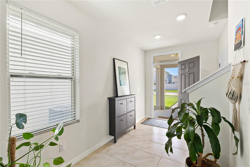 An entryway with tile flooring, a dark storage cabinet, a window with blinds, and a plant — 3090 TIMBER HAWK CIRCLE, OCOEE, FL