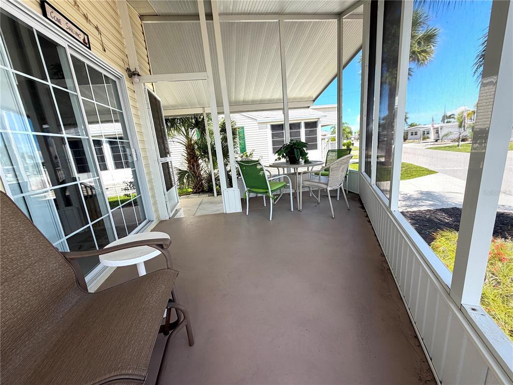 A living room features wood flooring, a coffee table, and a view into the kitchen — 817 S GREEN CIRCLE, VENICE, FL