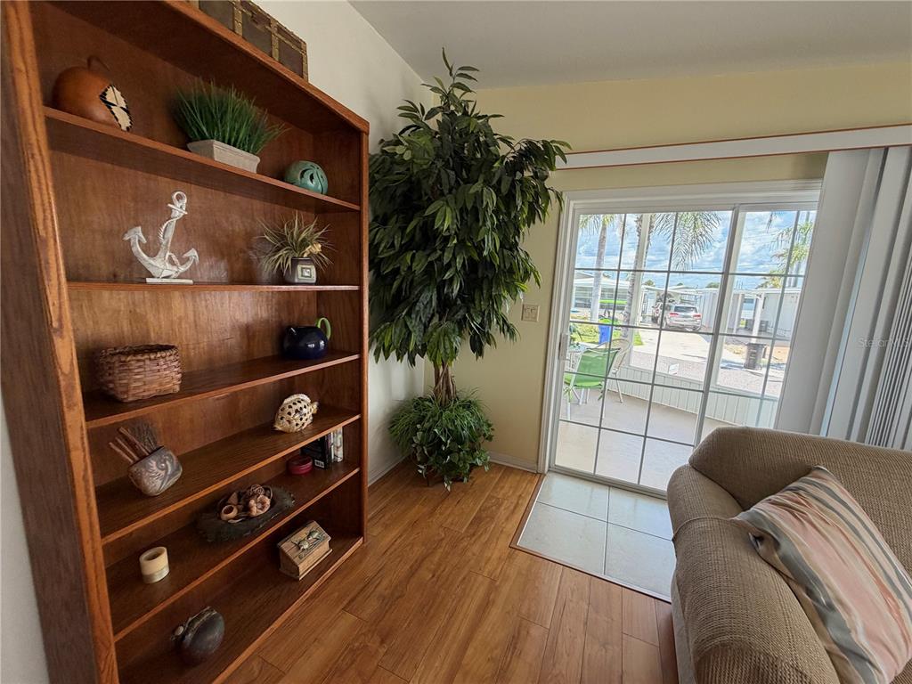 An open-concept kitchen and dining area features wood flooring, tile, and white cabinetry — 817 S GREEN CIRCLE, VENICE, FL