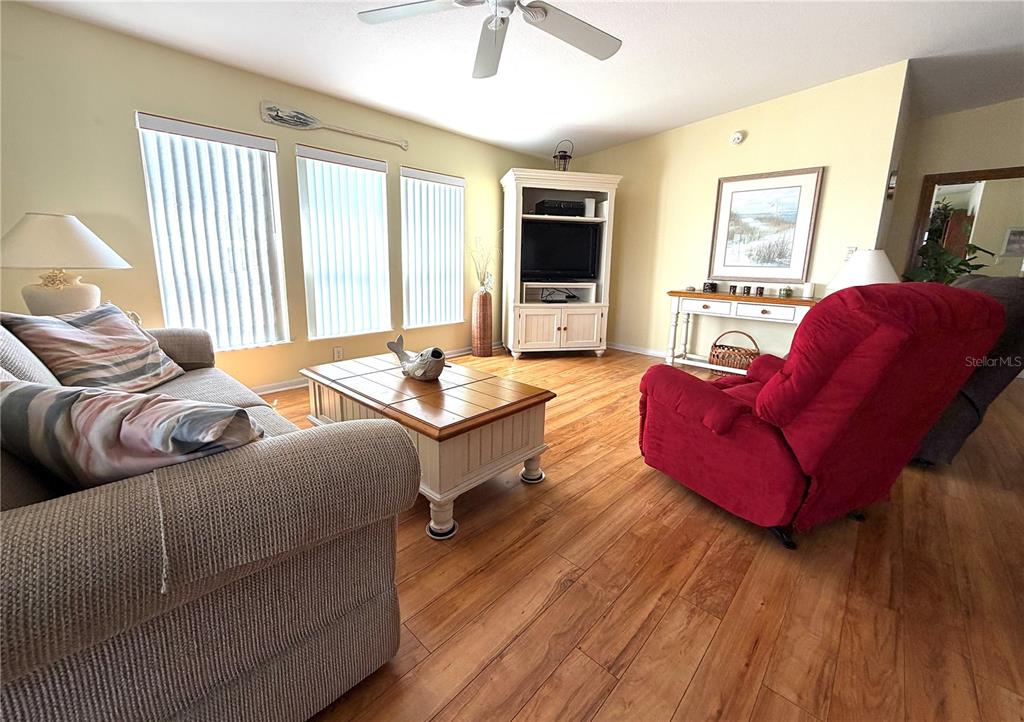 A kitchen features white cabinets, laminate countertops, a breakfast bar, and white appliances — 817 S GREEN CIRCLE, VENICE, FL