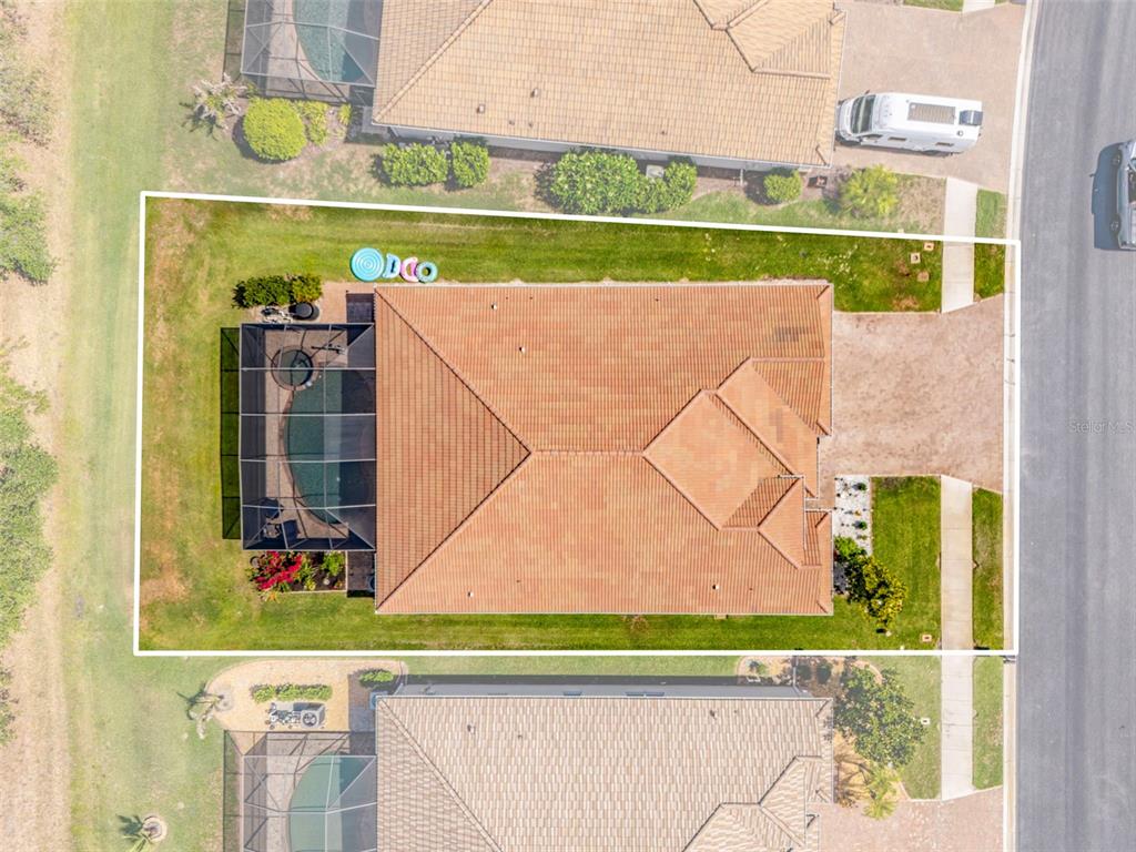 An aerial view shows a house with a tiled roof, pool enclosure, and surrounding lawn — 1934 MESIC HAMMOCK WAY, VENICE, FL