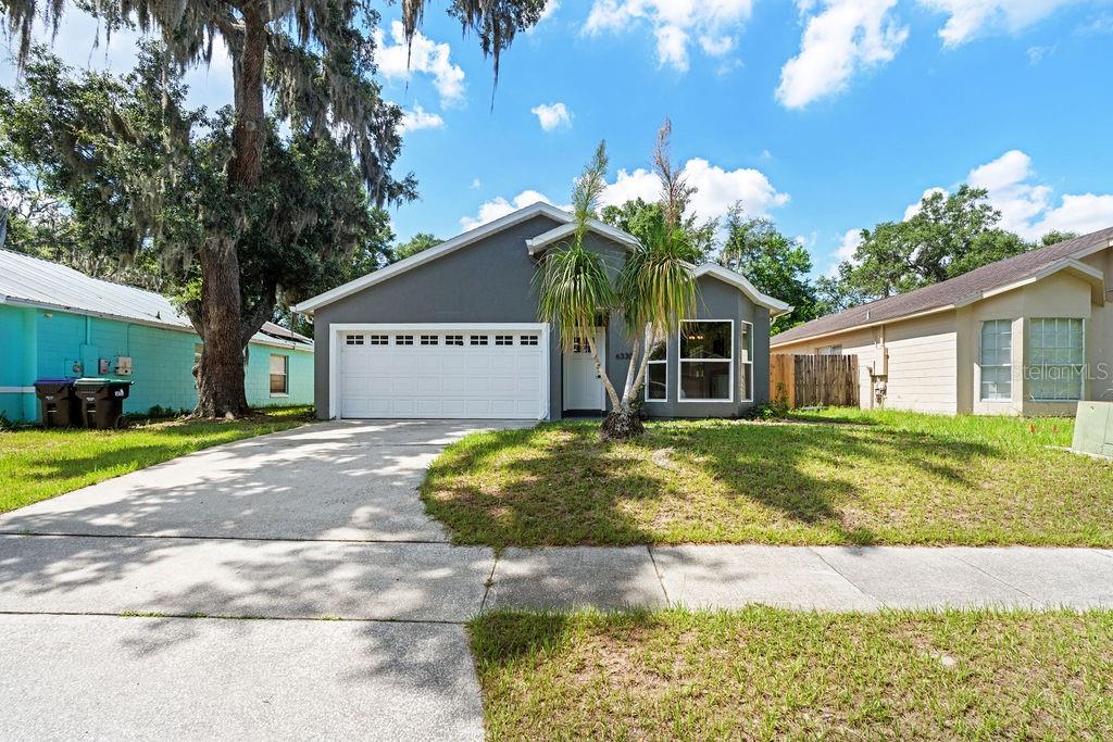 An aerial view shows a suburban house with solar panels on the roof and a driveway — 6330 RUTHIE DRIVE, ORLANDO, FL