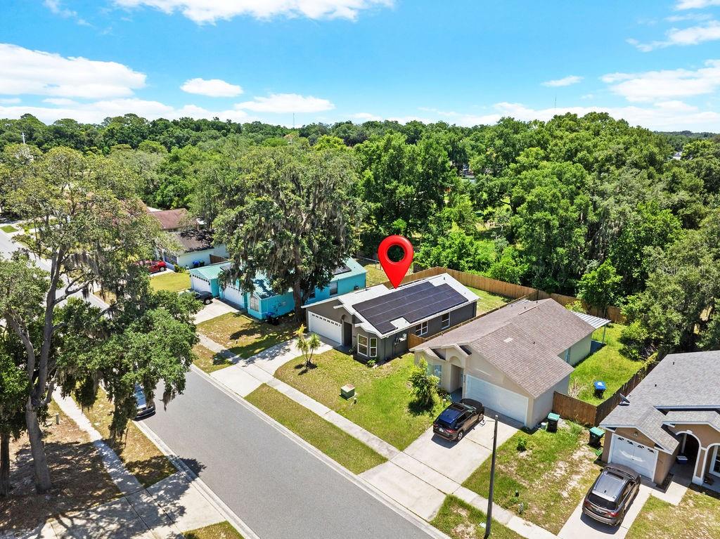 An aerial view of a residential house with solar panels on the roof and a backyard — 6330 RUTHIE DRIVE, ORLANDO, FL