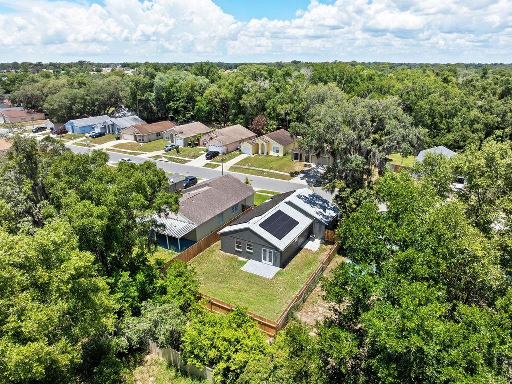 A modern kitchen features white cabinets, stainless steel appliances, and light wood-look flooring — 6330 RUTHIE DRIVE, ORLANDO, FL