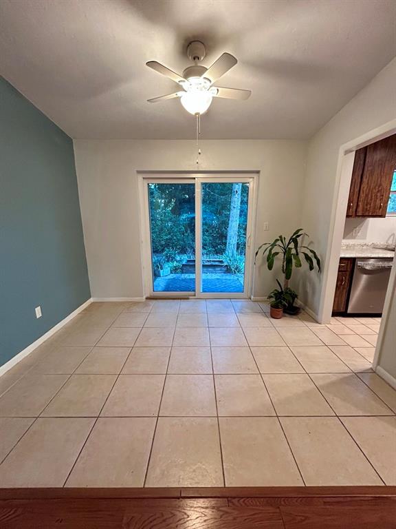 A dining area features tile flooring, a ceiling fan, and sliding glass doors to the outside — 4135 NW 30TH TERRACE, GAINESVILLE, FL