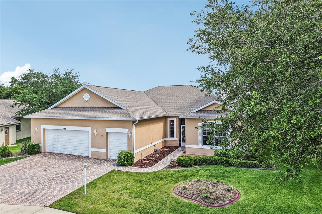 An aerial view of a suburban house with a paved driveway and surrounding green landscape — 3538 MULBERRY GROVE LOOP, LEESBURG, FL