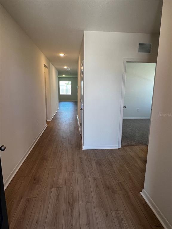 An entryway features a white console table, a round mirror, and a view into a bathroom — 12927 RED DEER PLACE, PARRISH, FL