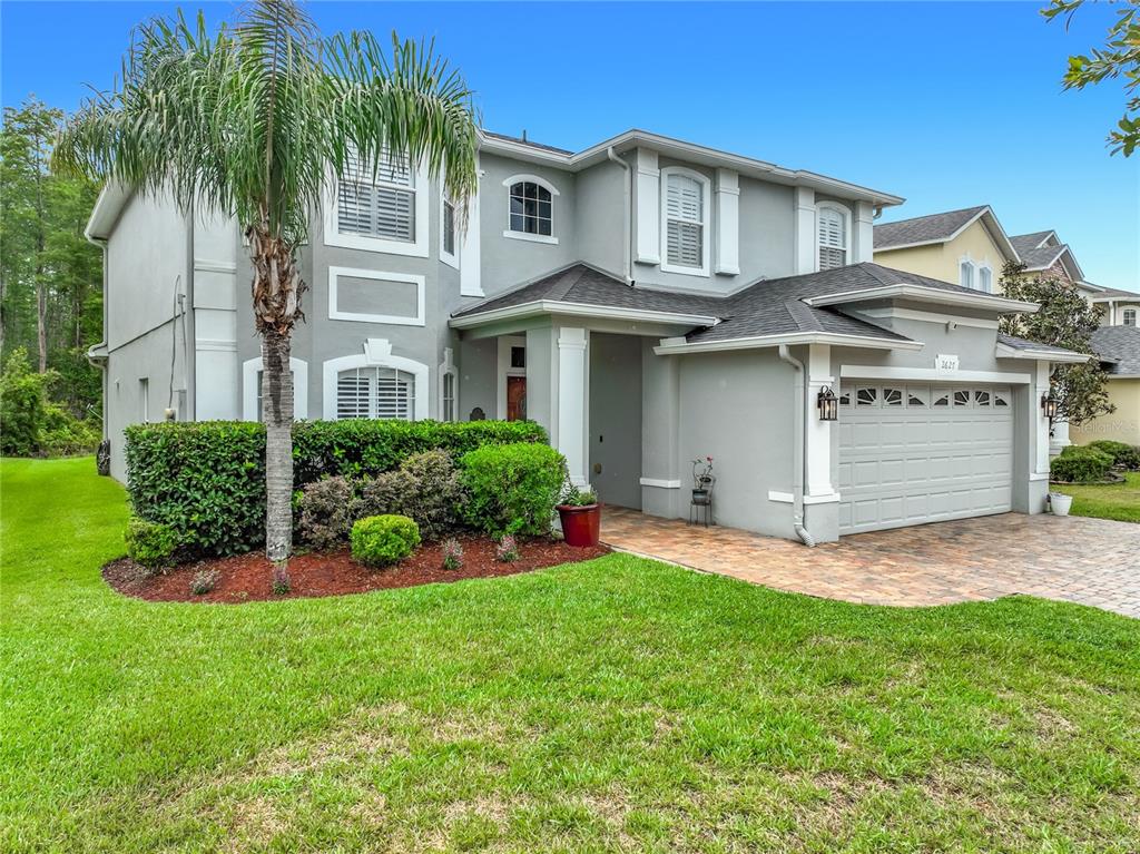 A two-story gray house with a palm tree, a two-car garage, and a paved driveway — 2627 LAKEMOOR DRIVE, ORLANDO, FL
