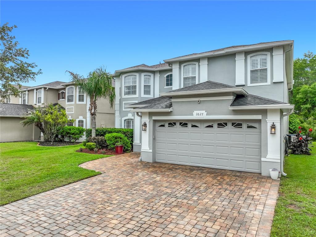 A two-story house with a gray exterior, a paved driveway, and a two-car garage — 2627 LAKEMOOR DRIVE, ORLANDO, FL