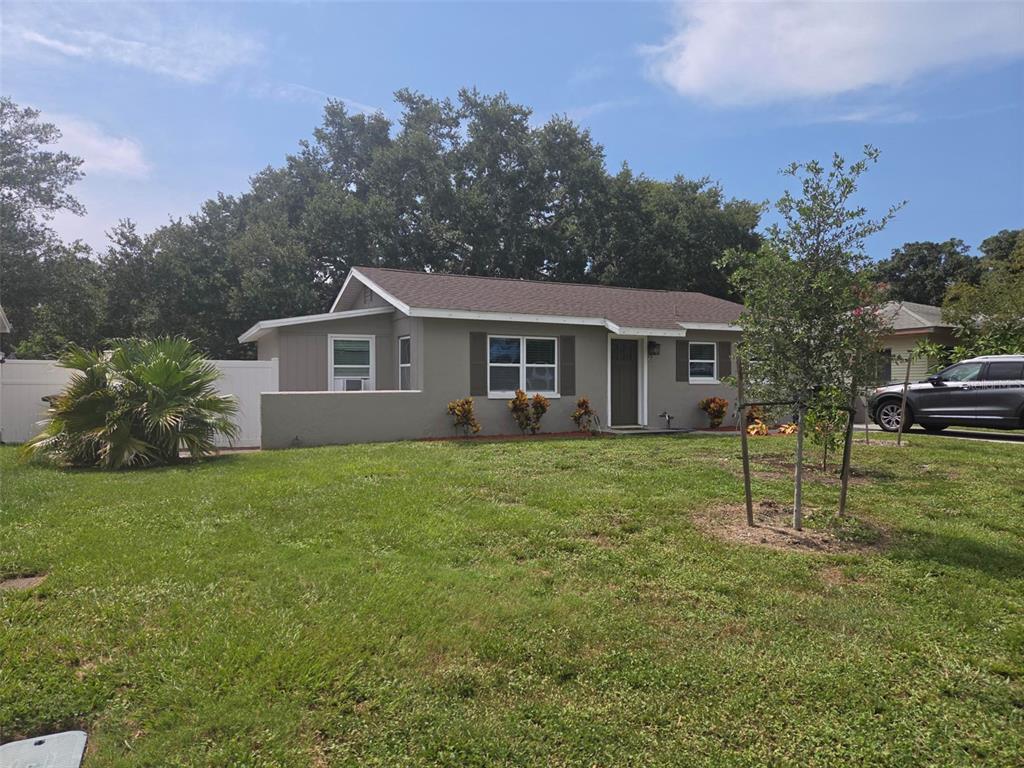 A single-story gray house with a brown roof sits on a grassy lawn — 20 S SATURN AVENUE, CLEARWATER, FL