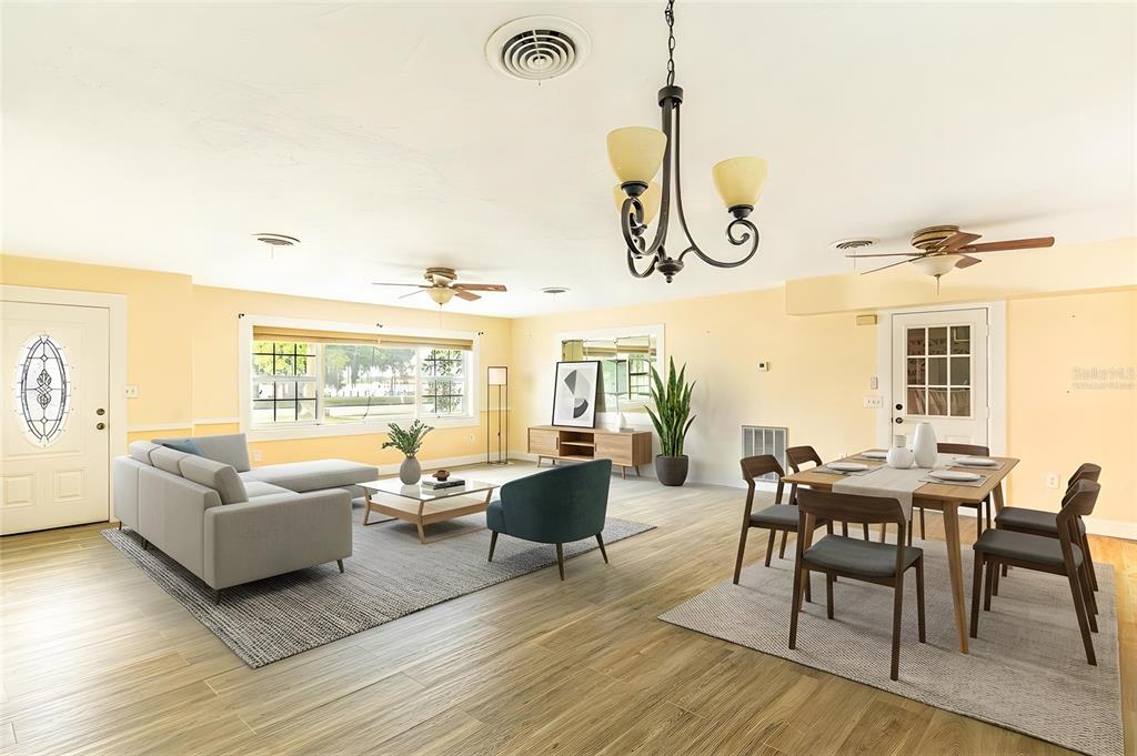 An open-concept living and dining room with light yellow walls and wood-look tile flooring — 3510 LAKEVIEW DRIVE, SEBRING, FL