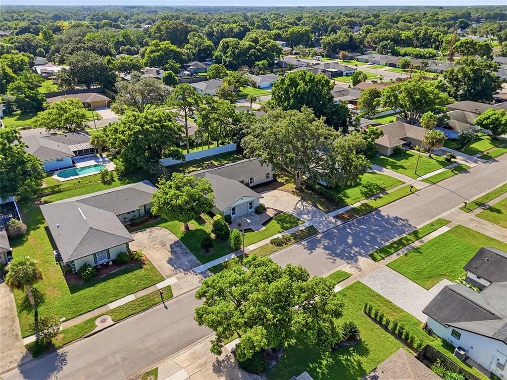 An aerial view shows several suburban houses with gray roofs, green lawns, and mature trees — 1011 MANCHESTER CIRCLE, WINTER PARK, FL