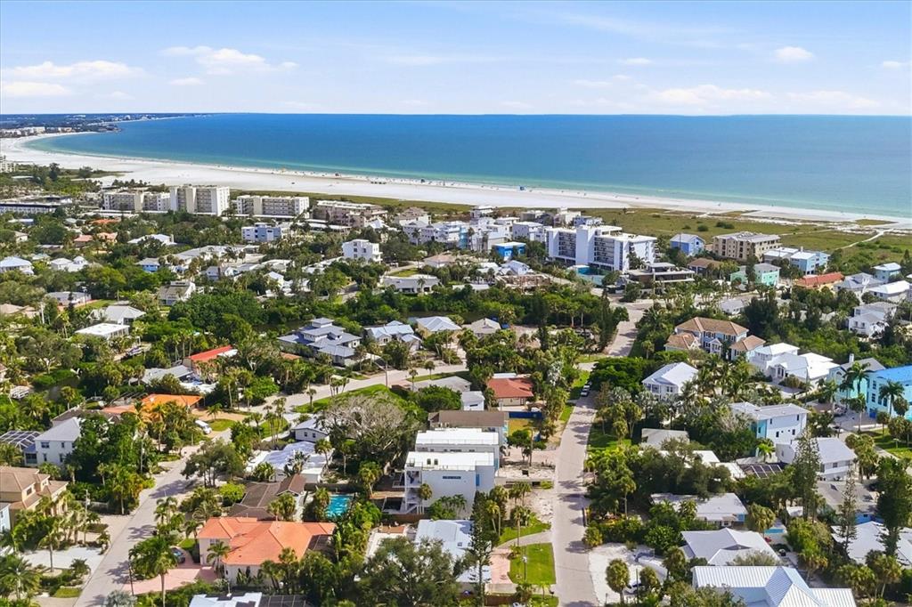 An aerial view of a coastal neighborhood with houses, palm trees, and a sandy beach — 5375 CALLE FLORIDA, SARASOTA, FL