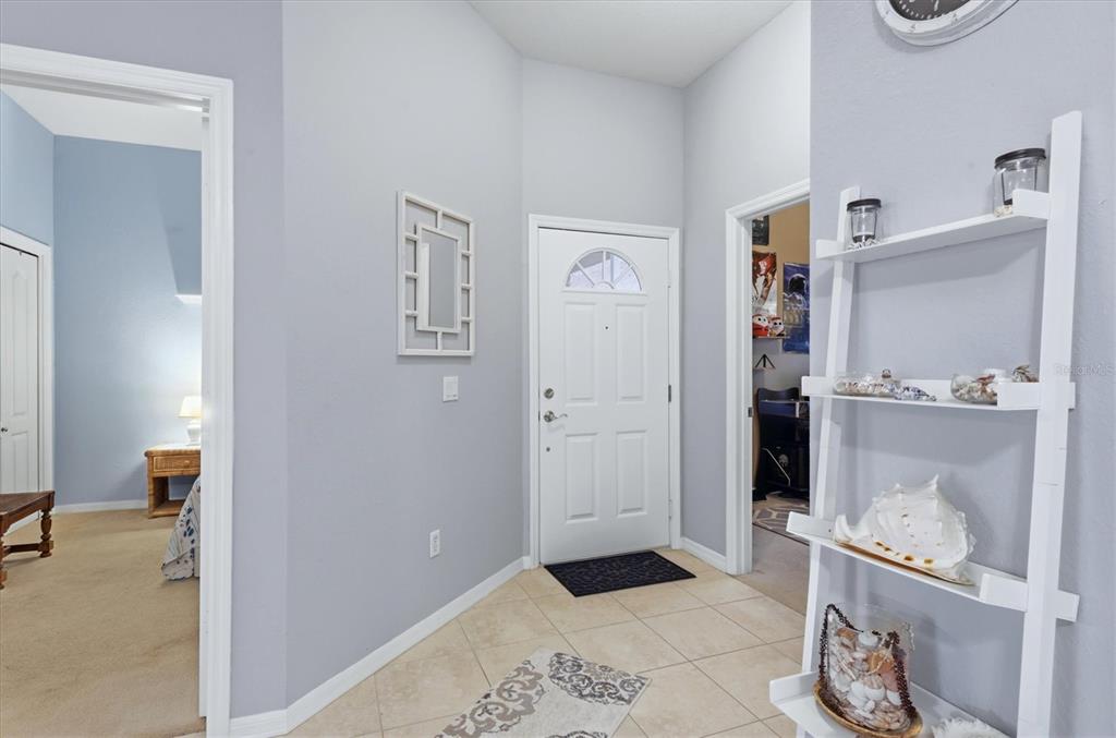An entryway with tile flooring, a white front door, and a white ladder shelf — 2175 LYNX RUN, NORTH PORT, FL