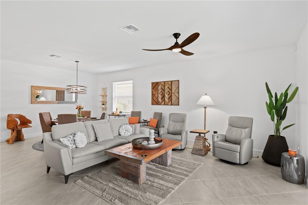 A living and dining area features light tile floors, a wooden coffee table, and furniture — 3390 WESTON MANOR DRIVE, ALVA, FL