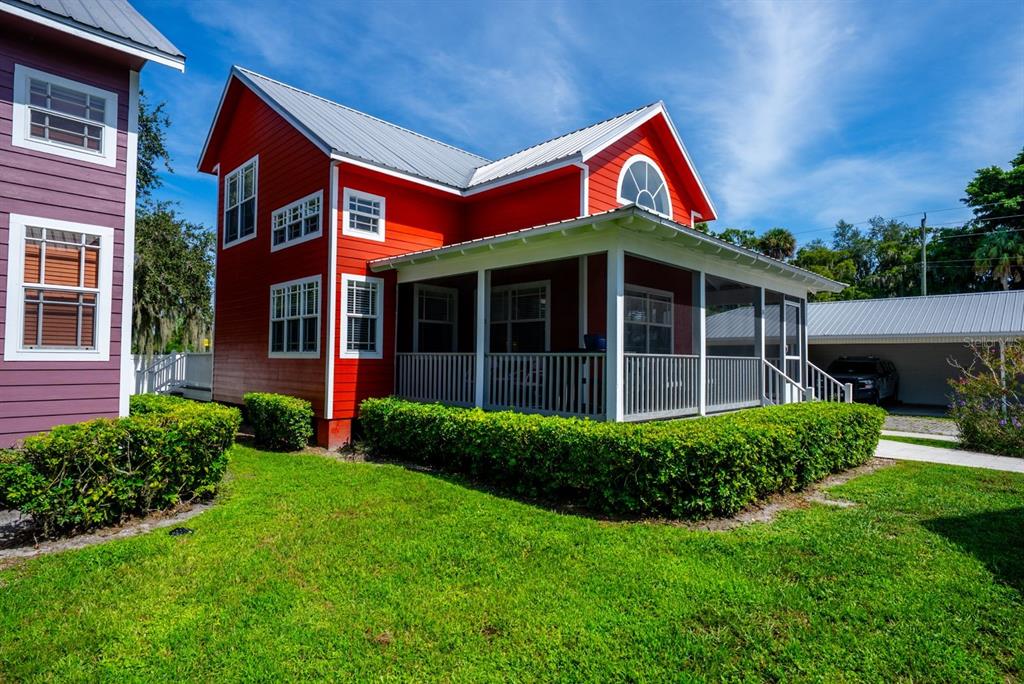 A two-story red house with a metal roof and a screened-in front porch — 4334 US HIGHWAY 441 SE UNIT 24, OKEECHOBEE, FL