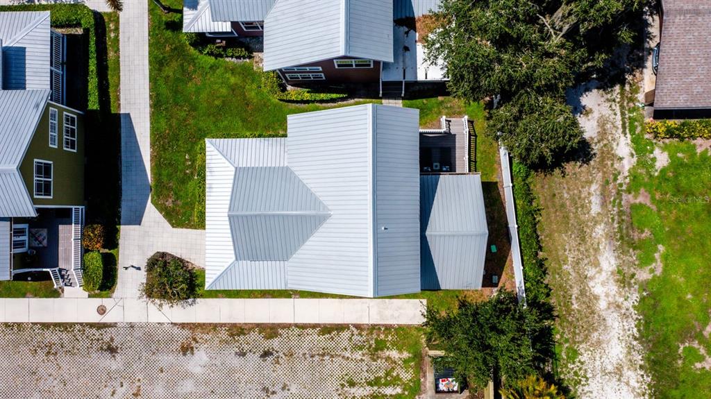 An aerial view shows the metal roofs of several houses surrounded by lawns and walkways — 4334 US HIGHWAY 441 SE UNIT 24, OKEECHOBEE, FL