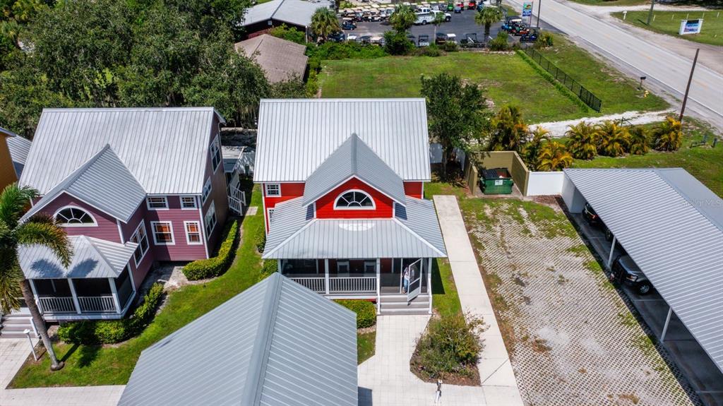 An aerial view shows a red house with a metal roof and a covered carport — 4334 US HIGHWAY 441 SE UNIT 24, OKEECHOBEE, FL